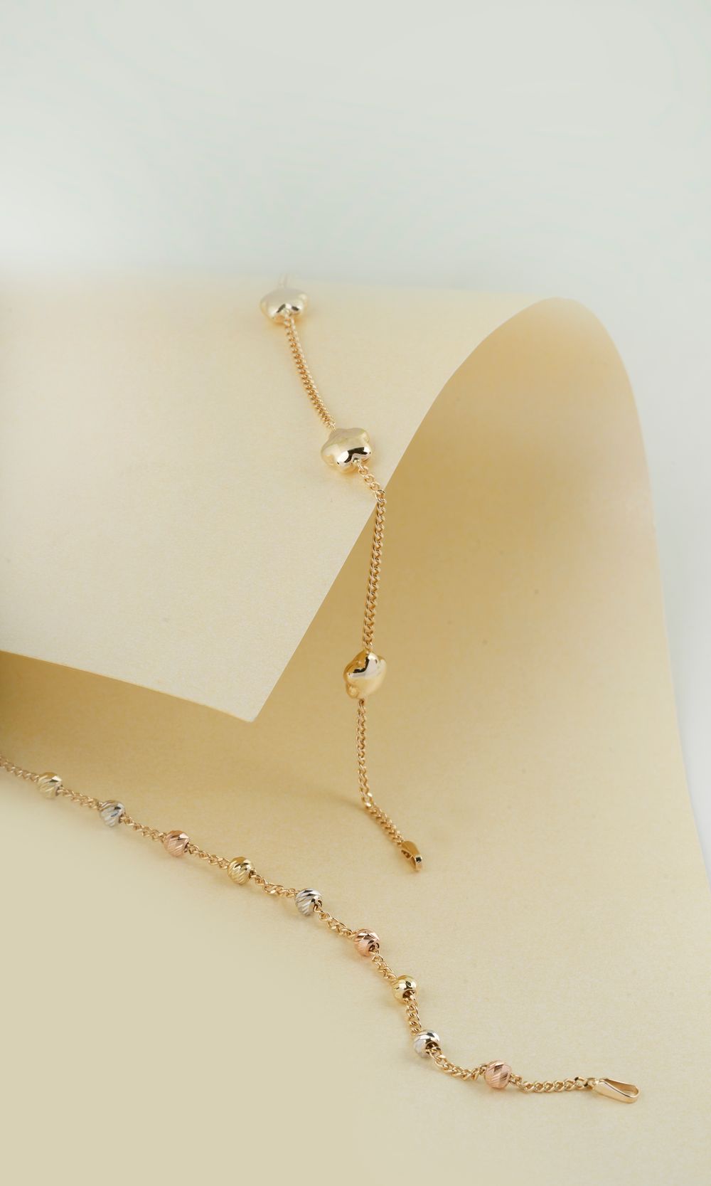 Collana in oro con ciondolo a goccia su tessuto crema